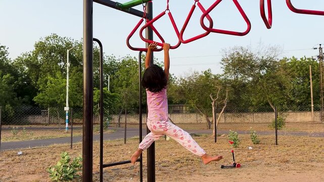 child enjoying healthy outdoor activity on monkey bars in public recreational park