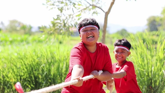 Two Indonesian kids in one team tried to pull the rope hard during the tug-of-war competition at Indonesia's Independence Day celebrations