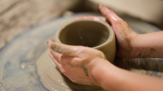 Artisan Hands Shaping Clay Pot on Spinning Pottery Wheel