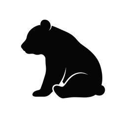 Black silhouette of a sitting bear cub. © First