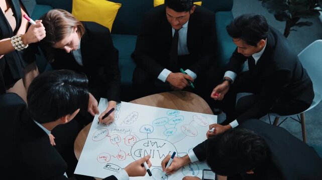 Top view of skilled diverse business people planning project by using mind map to brainstorm marketing idea. Smart start up team working together to draw mind map. Creative workplace. Directorate.