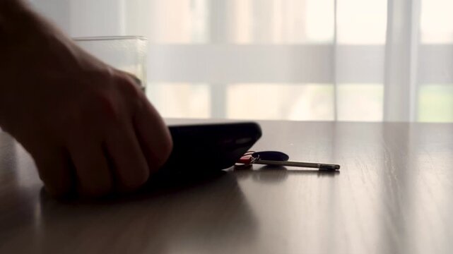 A Tranquil Morning Scene Featuring a Cup of Coffee, a Smartphone, and a Pen on a Wooden Table Bathed in Soft Natural Light Through Sheer Curtains
