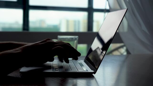 A Focused Moment: Engaging with Technology While Enjoying a Refreshing Beverage in a Modern Setting