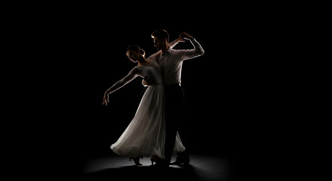 Graceful silhouette of a dancing couple against a dark background, captured in low key lighting.