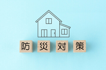 住宅のアイコンと防災対策の文字が書かれた木製のブロック © takasu