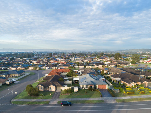 Aerial townscape of residential suburb in country town in Australia on morning with misty horizon