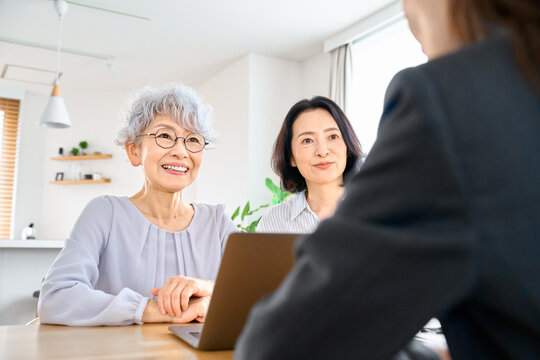 資産運用や保険や福祉の相談するシニア女性と家族