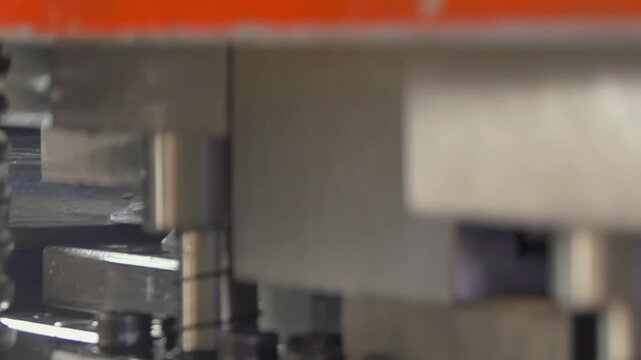Heavy machinery rhythmically presses textures into steel as precision engineering transforms raw materials into specialized hardware in a busy workshop.