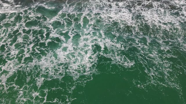 Aerial Turbulent Green Surf With Frothy Foam And Churning Eddies, Intense Whitewater Textures And Contrast Create Dramatic Natural Motion Ideal For Storm And Energy Scenes.