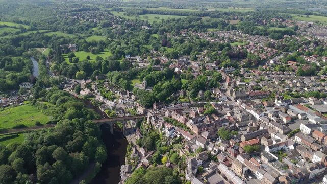 view of the iconic Knaresborough Viaduct spanning the River Nidd surrounded by lush green trees and traditional architecture.