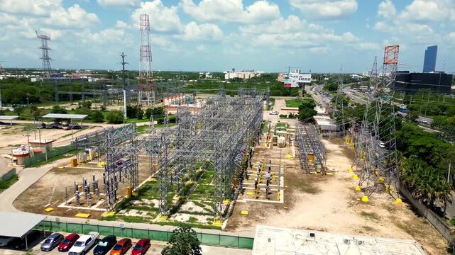 Merida, Yucatan, Mexico - 09 July 2026: Aerial view of electrical substation with metal structures, power lines, and surrounding industrial infrastructure under a cloudy sky.