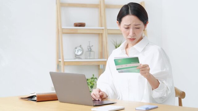 通帳を見て悩む女性。貯金、銀行、心配、不安、疑問、ローン、悩み、資金、困る、老後、貯蓄、不満、支払い