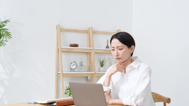 ノートPCに向かって話すミドル女性。web会議、ビデオ通話、レッスン、ウェビナー、配信、セミナー
