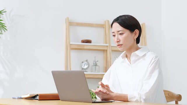 ノートPCに向かって話すミドル女性。web会議、ビデオ通話、レッスン、ウェビナー、配信、セミナー