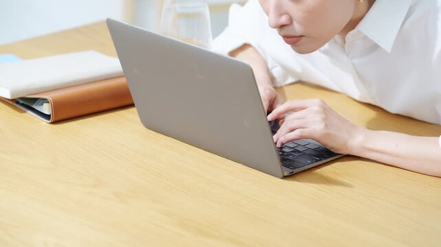 ノートPCにかじりついて見るミドル女性。真剣、仕事、投資、ギャンブル、熱中、集中、仕事、注目、不安