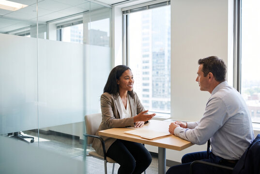 Hiring manager interviewing a professional candidate in a modern office