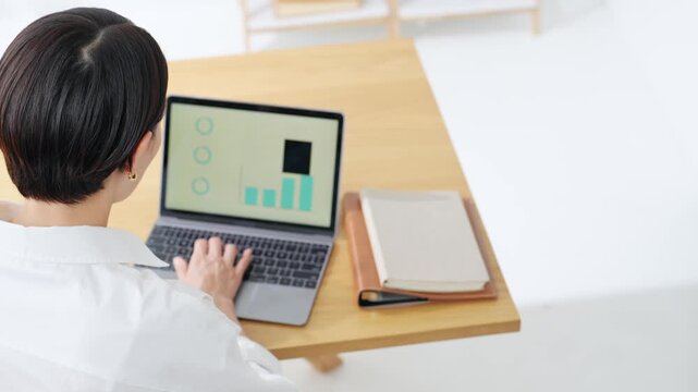 A woman using a laptop. Desk work, DX, work, freelance, remote work, office work, systems, working.