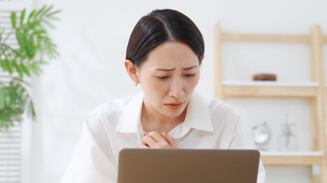 ノートPCを見てホッとするミドル女性。不安、心配、安心、解決、トラブル、笑顔、保険、ニュース、災害