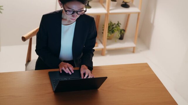 暗い部屋でパソコンを見るミドル女性。デスクワーク、テレワーク、フリーランス、仕事、SE、エンジニア