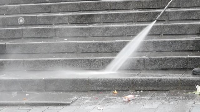 High pressure washer cleaning outdoor stone stairs removing dirt and debris