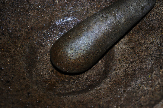 Traditional Indonesian Stone Mortar with Detailed Natural Rock Texture on Black Background Copy Space