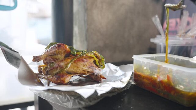 Hands Applying Sauce to Cooked Grilled Chicken