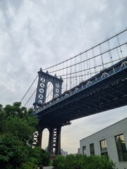 Fototapeta premium Low angle view of the Manhattan Bridge against a cloudy sky in New York City.