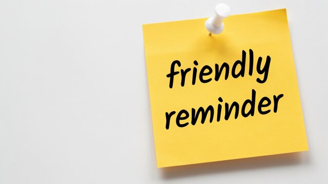 "Friendly reminder" on yellow sticky note, pinned with a pushpin, isolated on white background.