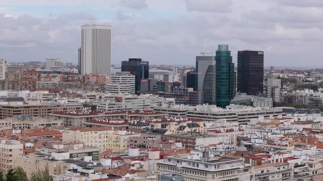 Madrid, Spain - 12 June 2026: Aerial view of AZCA financial district skyscrapers and dense urban residential blocks under a cloudy sky in Madrid, Community of Madrid, Spain.