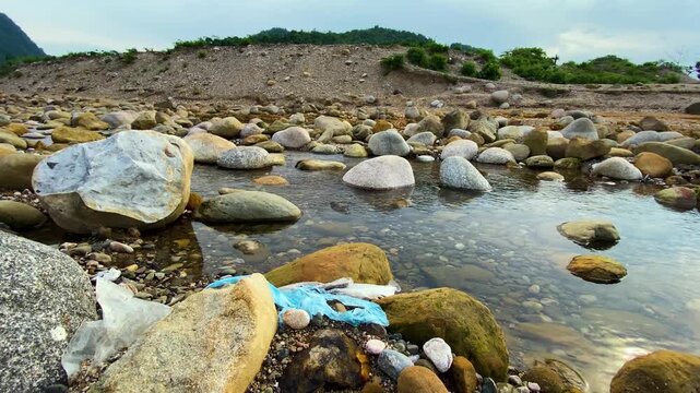 Polythene Plastic Waste Polluting Rocky Mountain River Stream Nature at a Tourist spot in Sylhet, Bangladesh