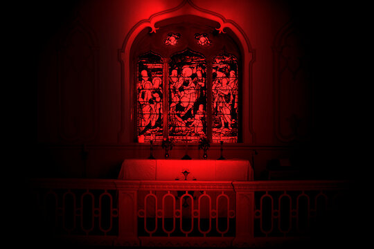 Red abstract image of a church alter interior with a stained glass window. Halloween spooky scary background backdrop.