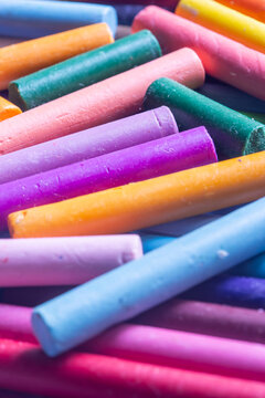 Pastels wax crayons, in various bright colours, background backdrop. Art and craft supplies concept