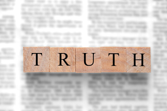 Newspaper background with wood blocks on top with the word truth. Written press news media concept