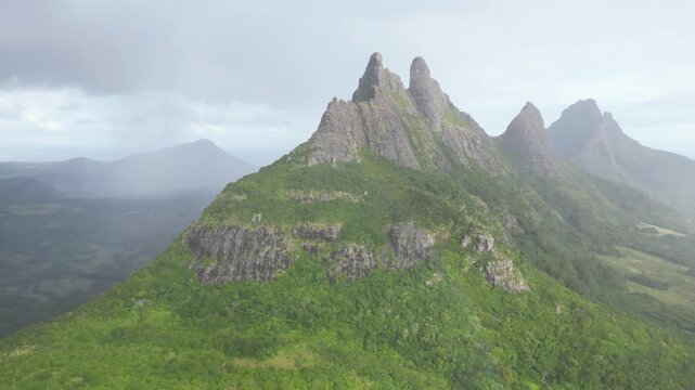 Aerial drone shot capturing the steep volcanic peaks and green slopes of Montagne du Rempart near Flic en Flac in Mauritius.