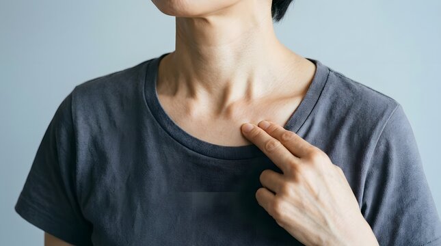 鎖骨付近の痛みや不快感を調べる女性