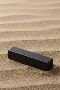 A cast iron paperweight on dry sand surface
