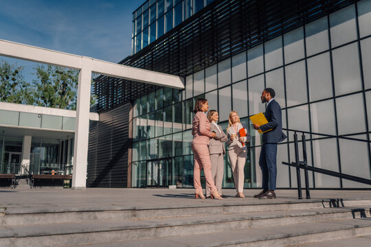 Business executives discussing strategy outside modern office building