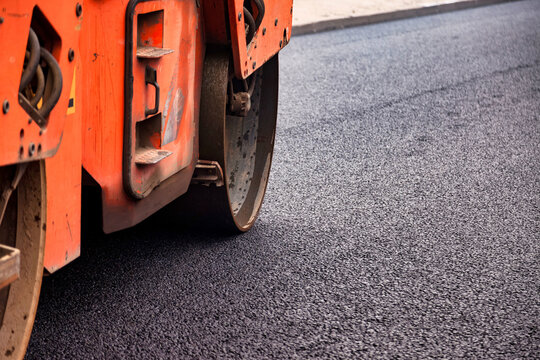 Urban Asphalt Paving Works Show Construction Equipment on a Recently Laid Road Surface