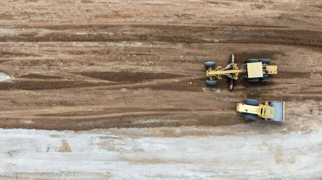 Aerial view motor grader civil at construction site, Motor grader work on construction site, Road grader on road construction site machine work on the construction of new road.