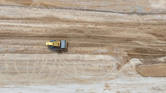 Aerial view motor grader civil at construction site, Motor grader work on construction site, Road grader on road construction site machine work on the construction of new road.