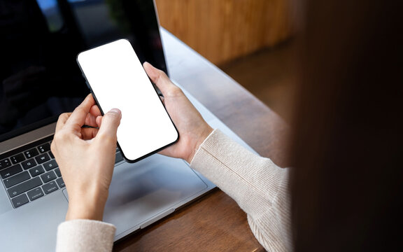 Woman holding modern smartphone with empty white screen mockup for mobile apps, branding and marketing. Close up of mobile device with clipping path for screen.