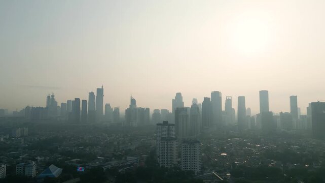 Silhouetted City Skyline at Hazy Sunrise with Dense Air Pollution