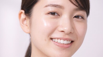 Obraz premium Close up portrait of a young Japanese woman smiling with clear skin.
