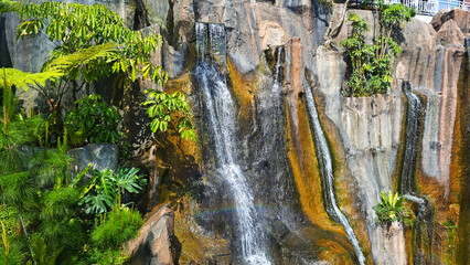 mighty waterfalls with mossy cliffs in the mountains with tropical plant © umi