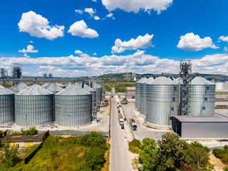 Grain storage facility located in an industrial area with silos under a clear blue sky during the daytime © DSMT