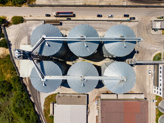 Grain storage facility with silos and equipment seen from above during daytime in a rural location © DSMT