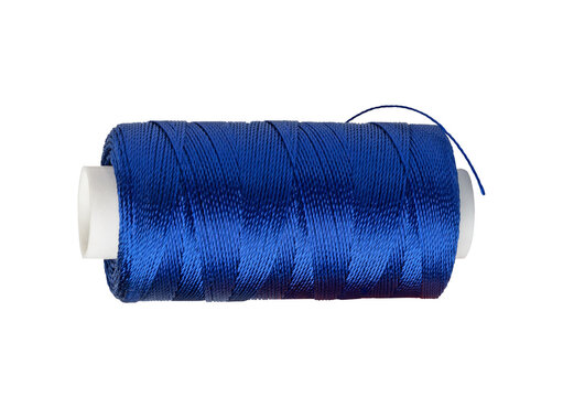 Dark blue sewing thread on white spool for textile manufacture.