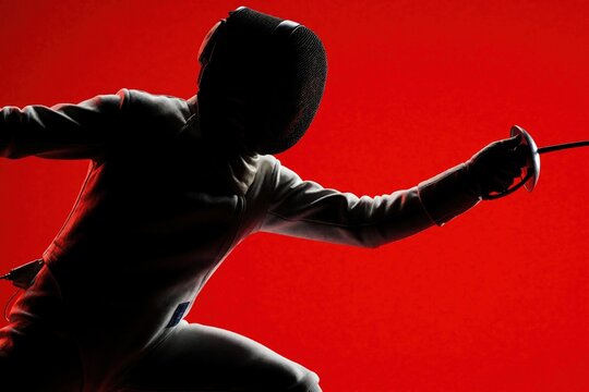 Fencer in aggressive pose holds foil sword with determined expression. Athlete wears protective mask, uniform against vibrant red background. Intense combat stance shows focus, agility, quick