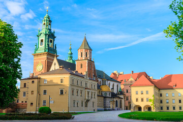 Naklejka premium historic Royal Castle and Cathedral stand majestically against a bright blue sky, showcasing centuries of Polish architecture and heritage