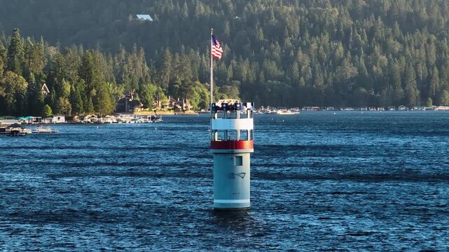 Telephoto drone shot flying around Lake Arrowhead outlet tower California, sunset